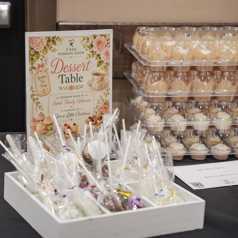 CASA Fashion Show garden tea party dessert table sign with wrapped cake pops and cupcakes