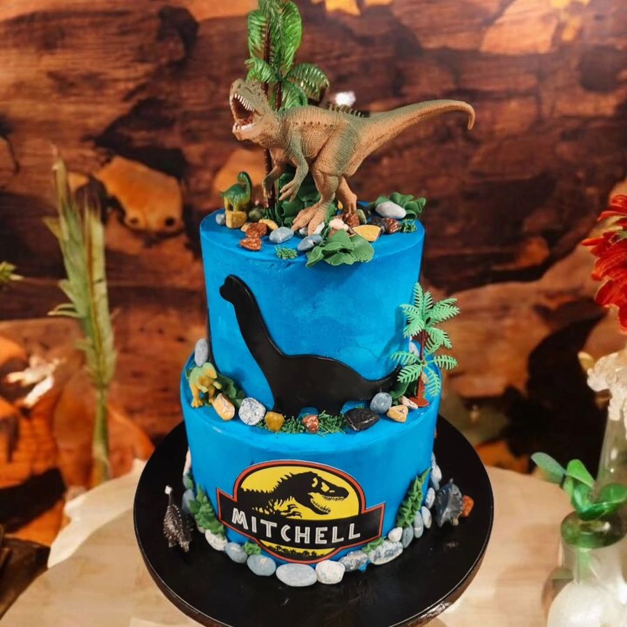Two-tier blue Jurassic Park dinosaur cake