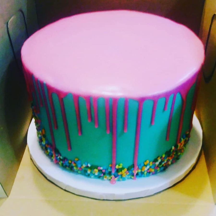 Teal cake with hot pink drip and rainbow sprinkles