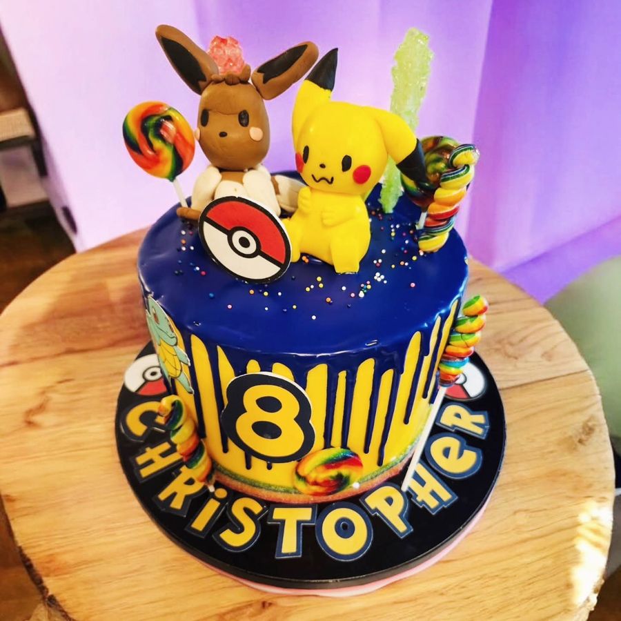 Navy and yellow drip cake with Pikachu and Eevee for an 8th birthday