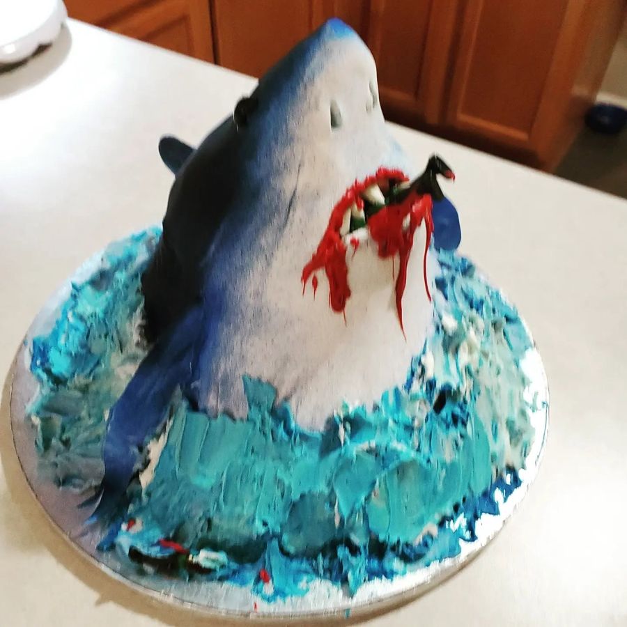 Sculpted great white shark bursting from buttercream waves
