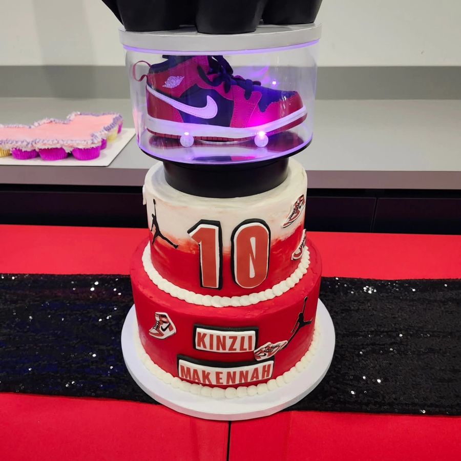 Two-tier red sneaker cake for a 10th birthday with a lit shoe display topper