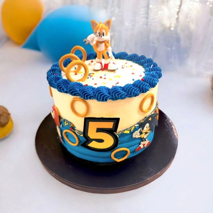 Blue and white Sonic cake with Tails, gold rings and a number 5