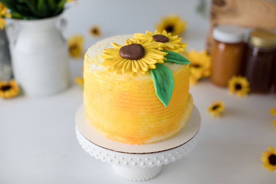 Yellow textured buttercream cake topped with sunflowers