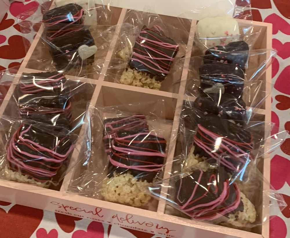 Valentine Rice Krispie treats dipped in chocolate with pink and red drizzle
